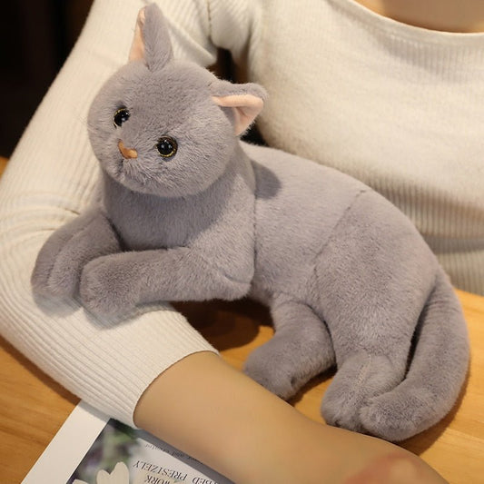 a lady holding a gray color stuffed cat that has touch like a real cat