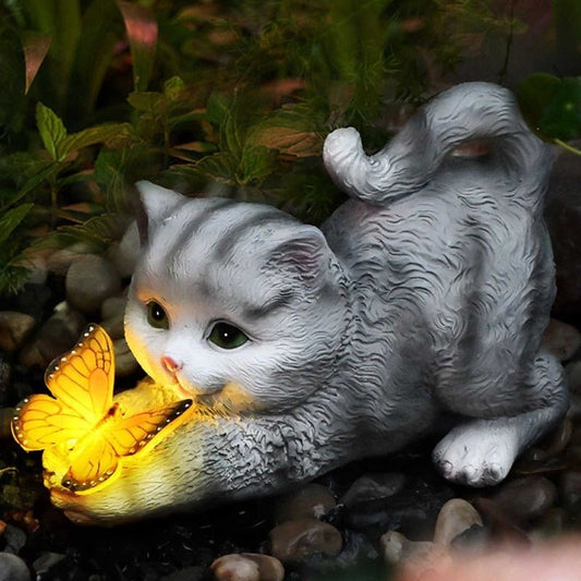 a solar powered butterfly and playful cat sculpture for outdoor garden