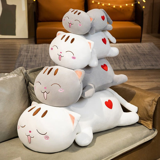 various sizes of grey cat plush laying on the couch
