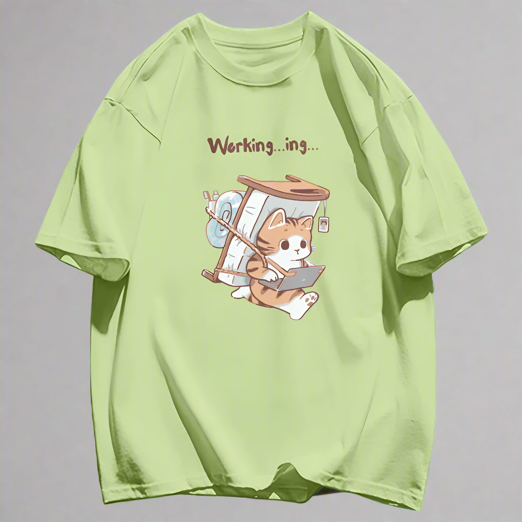 Light green cartoon cat theme t-shirt with a cat character carrying a mattress and 'Working...ing' text representing a work from home cat