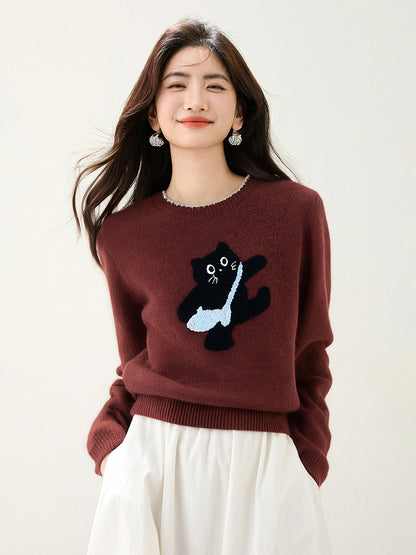 Woman wearing a dark red sweater with a design of a black cat carrying. blue fish shape bag