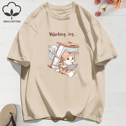 Beige t-shirt with a cat illustration carrying a mattress and working hard and 'Working...ing' text