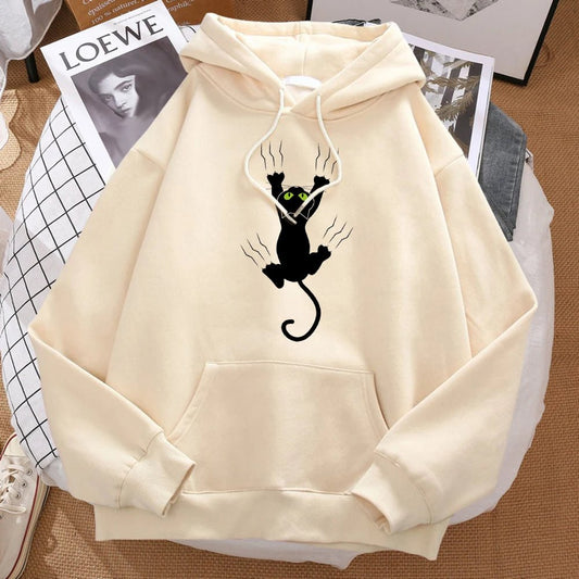 Beige hoodie showcasing a desperate black cat clawing to stay on the wall and looks funny