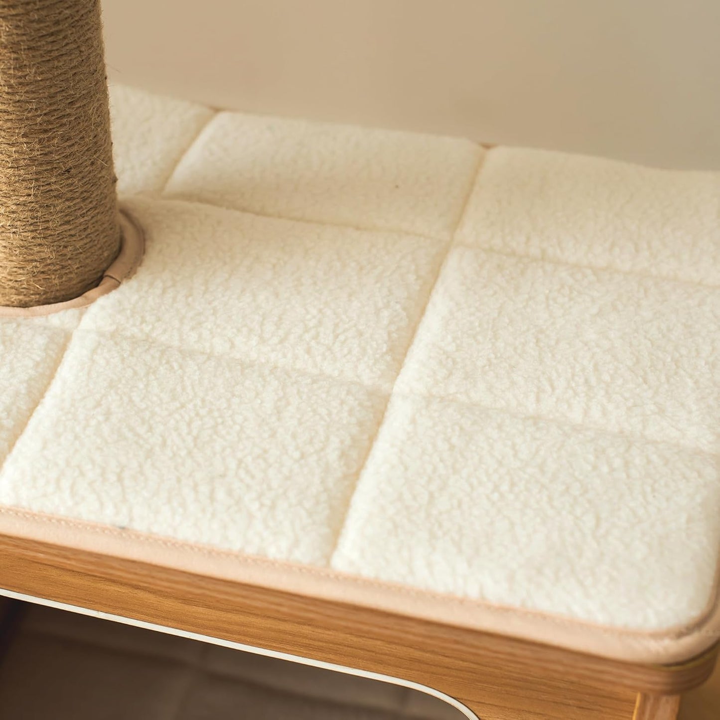 Cat tree with a textured cushion and wooden base