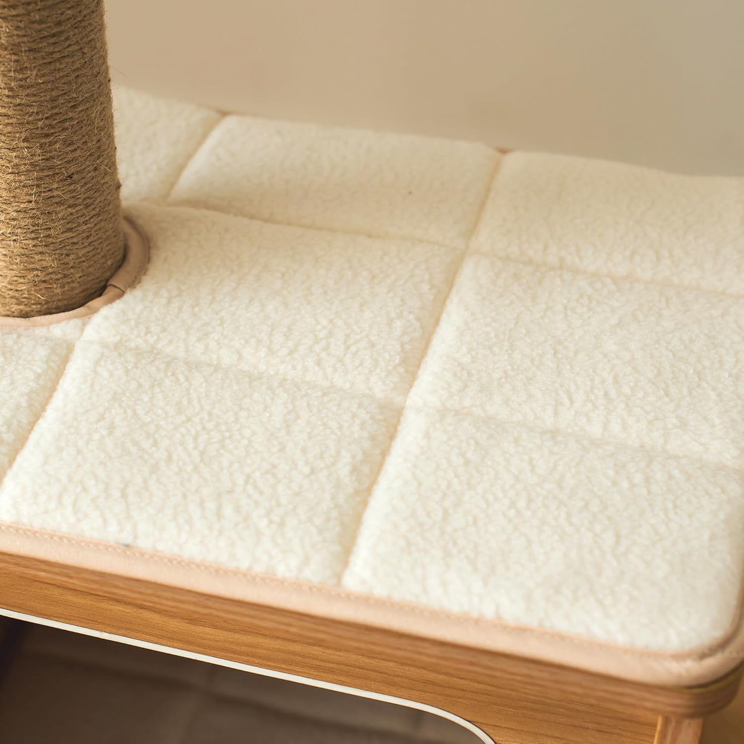 Cat tree with a textured cushion and wooden base