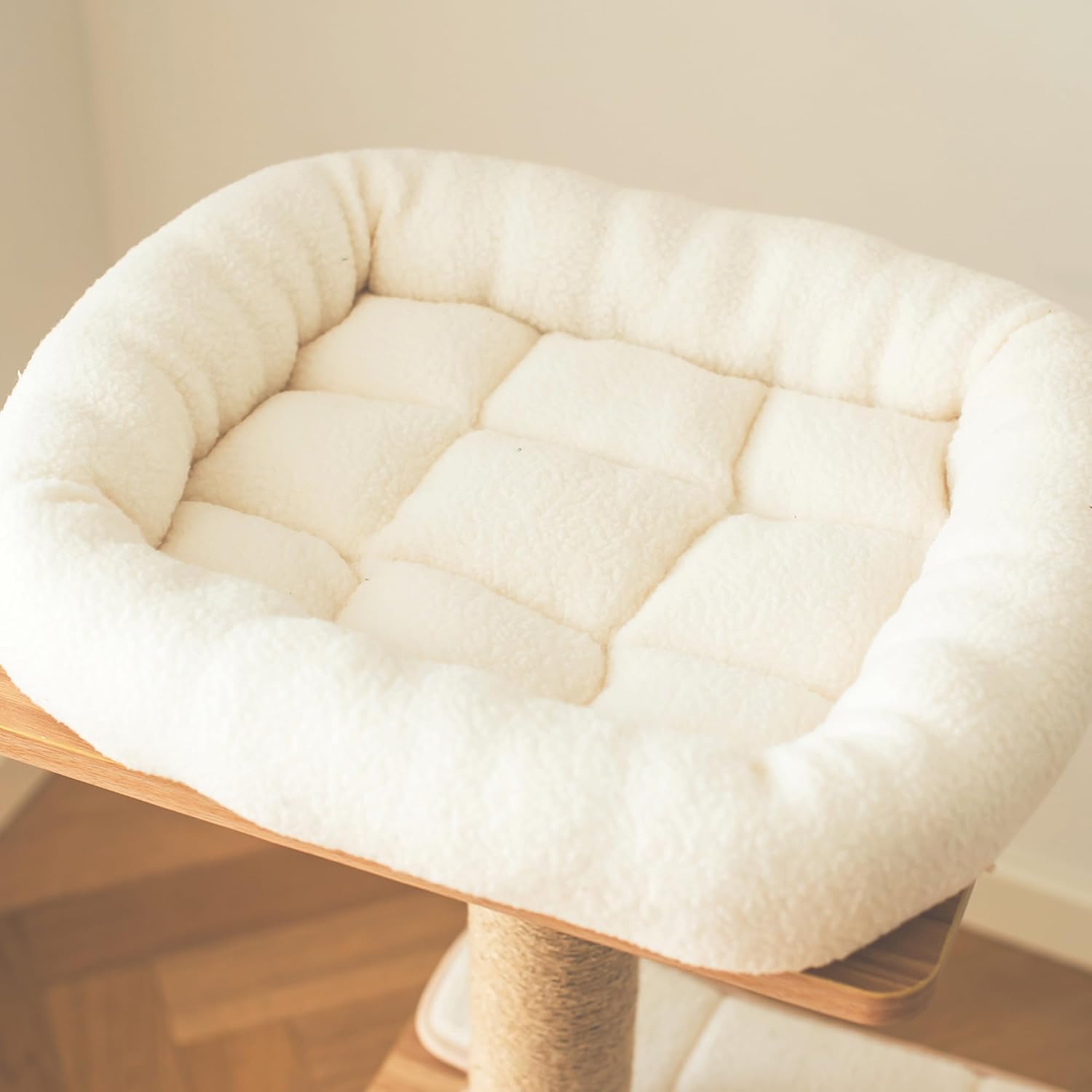 White cushion on a wooden stool with a neutral background