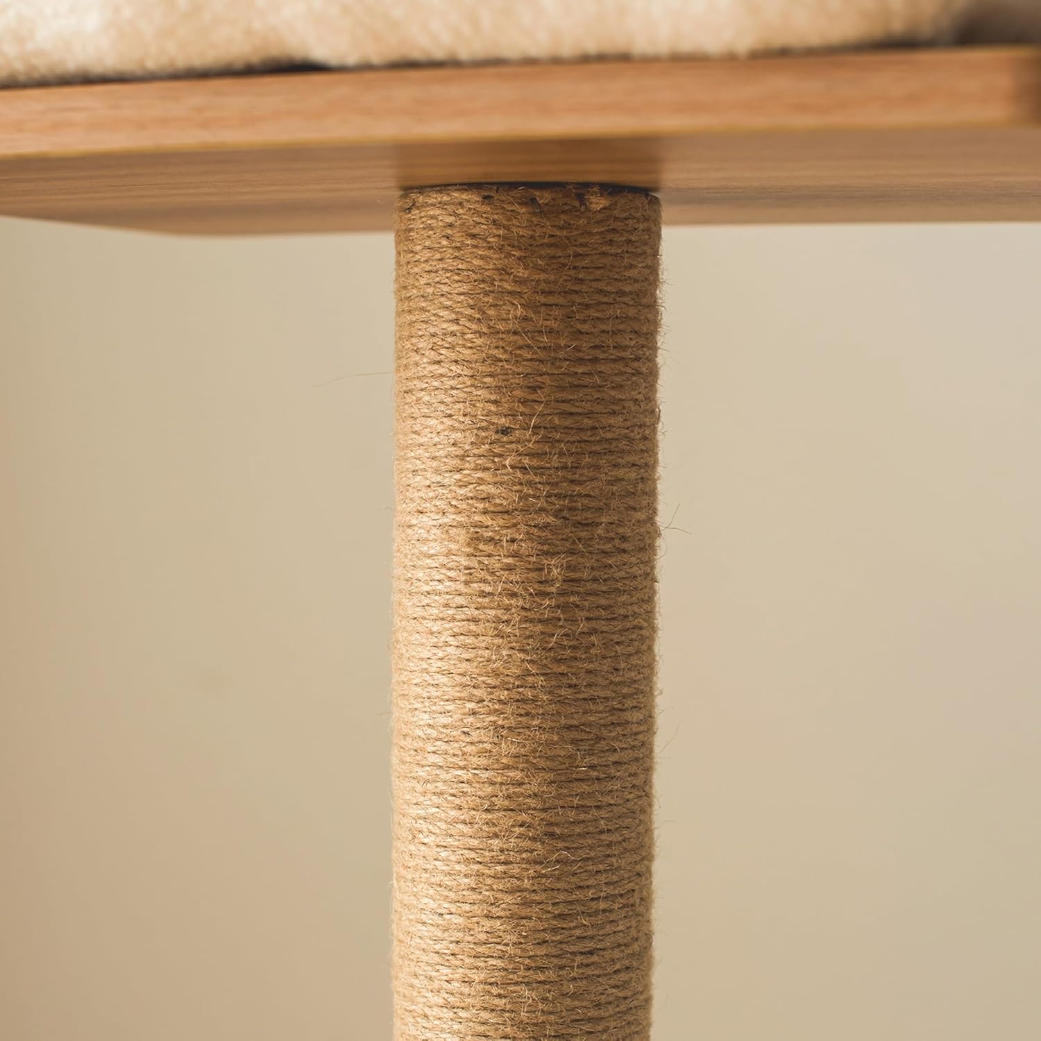 Close-up of a cat tree with a textured wooden post and cushioned top.