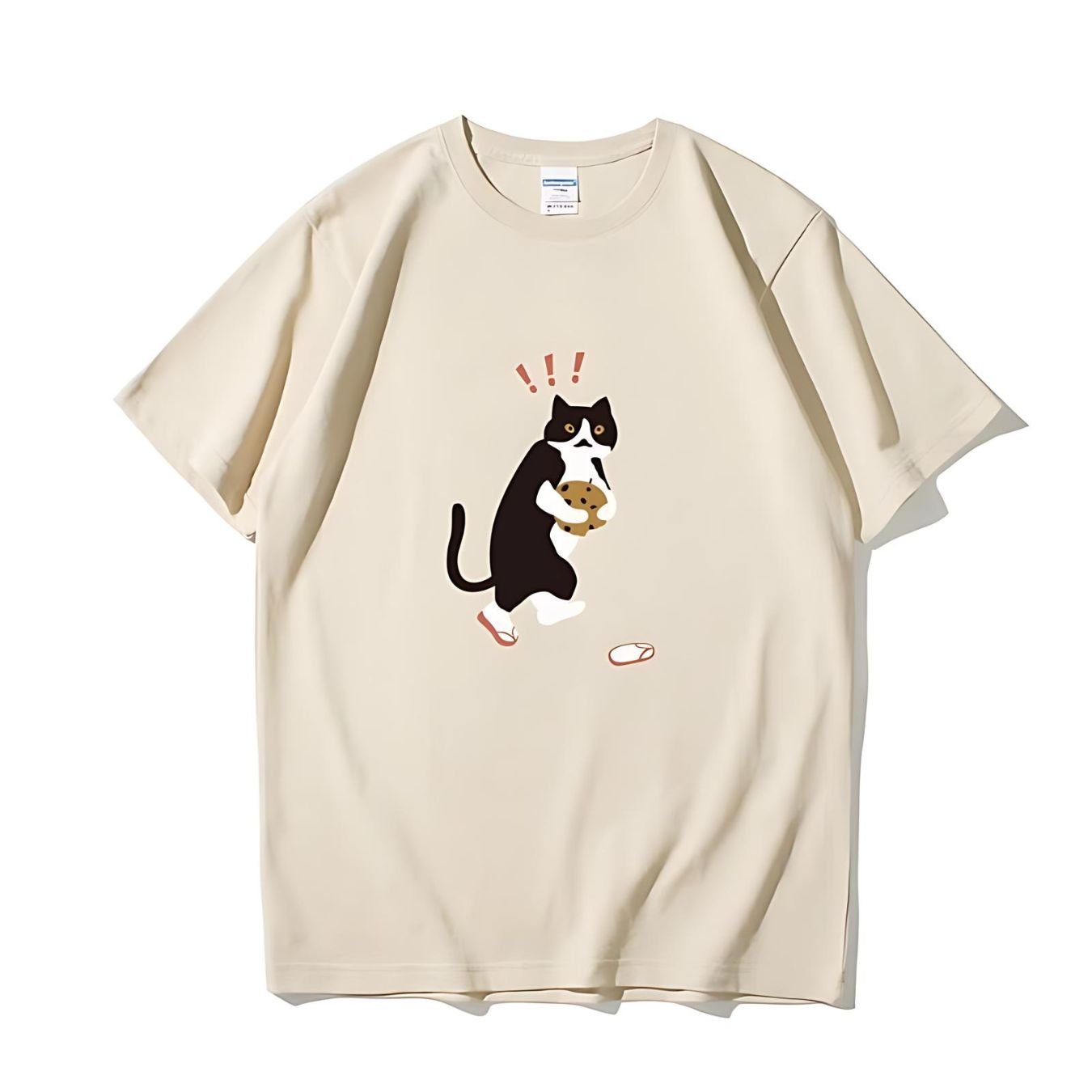 Cute black and white cat holding a stolen cookie on beige t-shirt