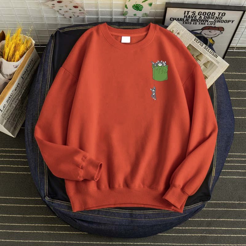 a brick red cat print sweatshirt with a printed pocket full of cats