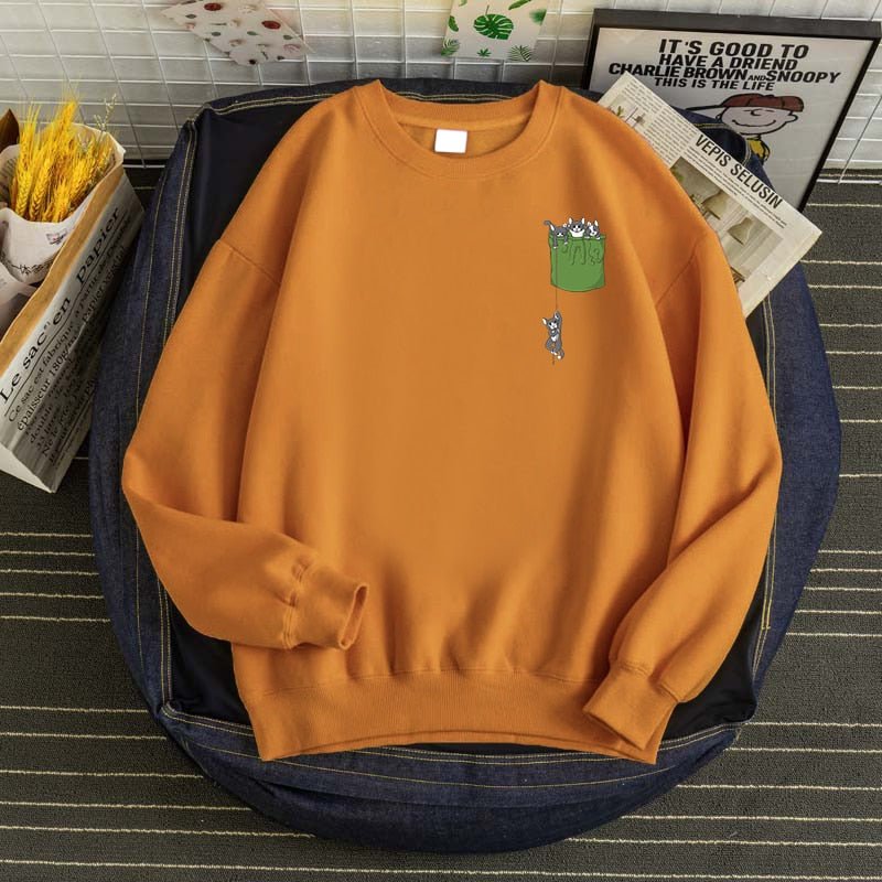 A khaki color sweatshirt with cat featuring a printed pocket of cats
