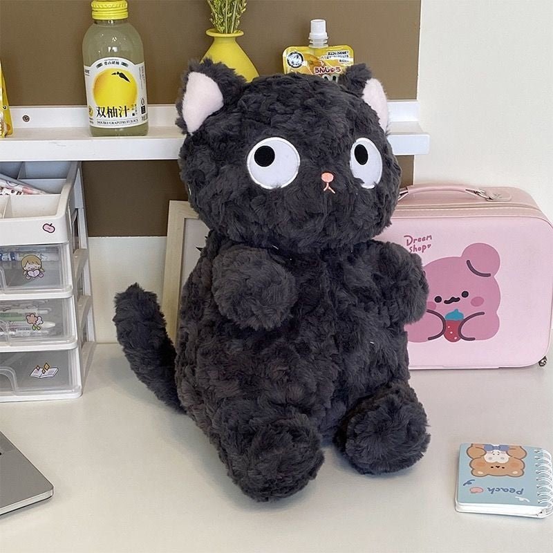 a cute plushies of a black cat on a table