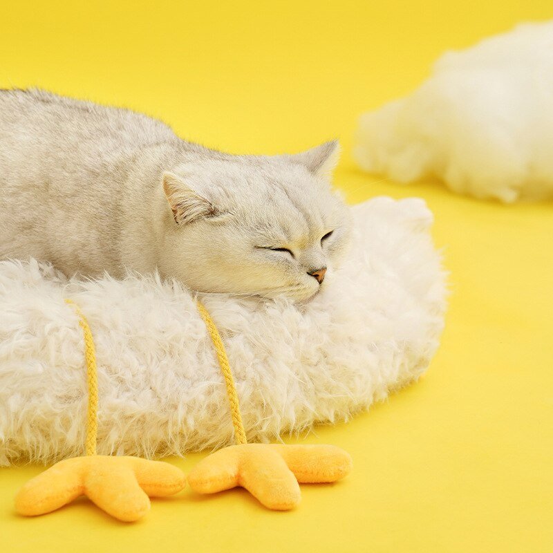 cat sleeping on a fluffy cat bed in cute chicken design with yellow chicken feet