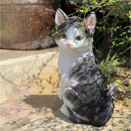 a realistic cat statue of a tabby cat for outdoor garden in a sitting pose with the head turns back