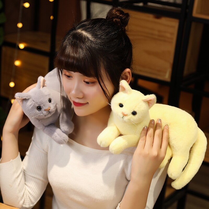a woman with realistic cat plush on her shoulder