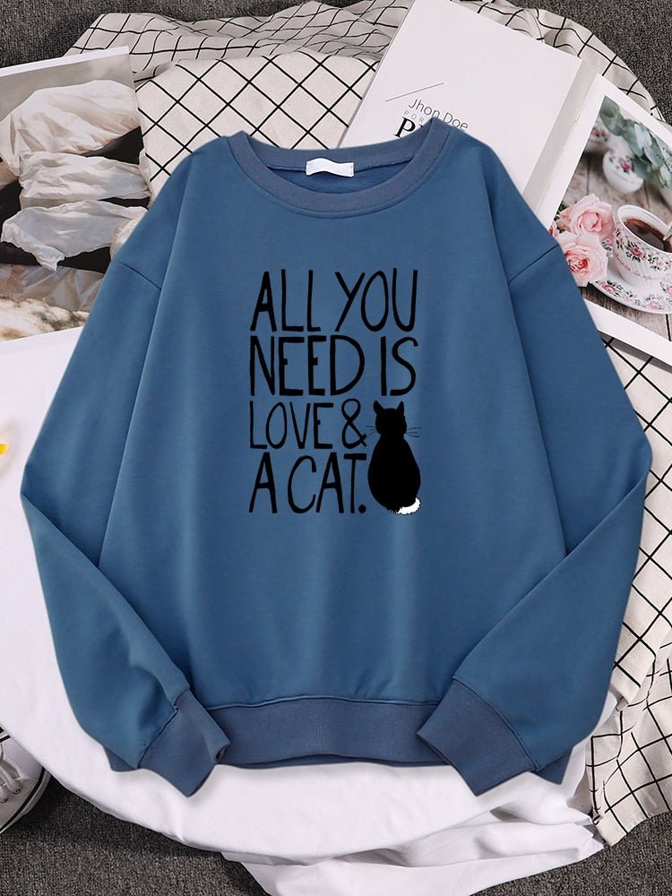 a blue color black cat sweater with the word all you need is love & cat