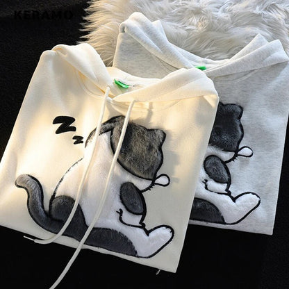 Fluffy cat snoring design on the back of the beige and gray hoodie