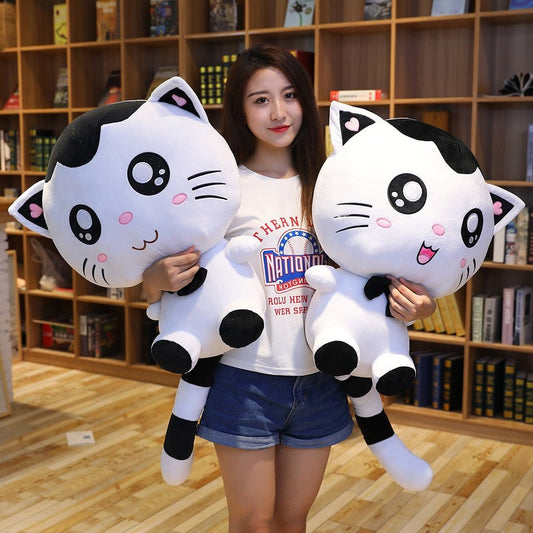 a lady hugging black and white cat plush with big eyes
