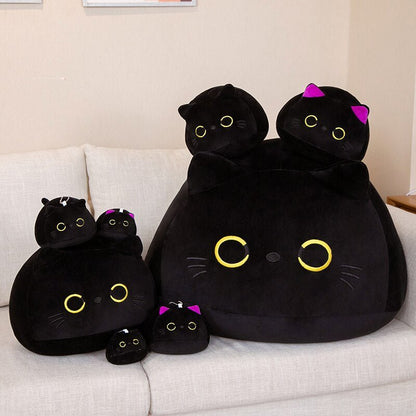 cute plushies of a black cat with yellow eyes in different sizes