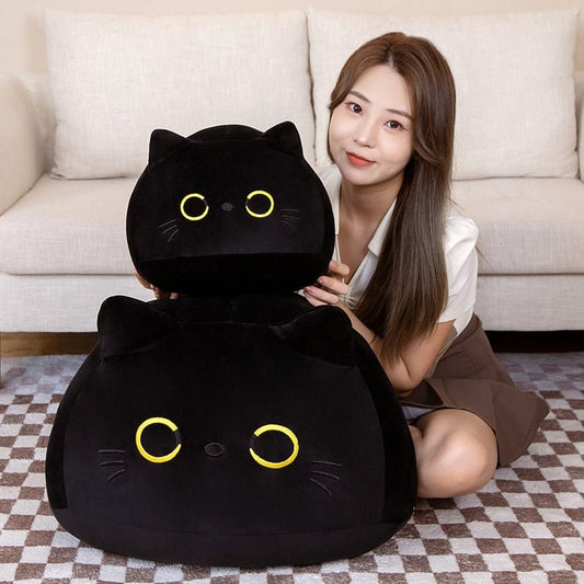 a lady holding a big black cat plushie with yellow eyes