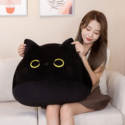 a lady holding a giant cat plush of a black cat with yellow eyes