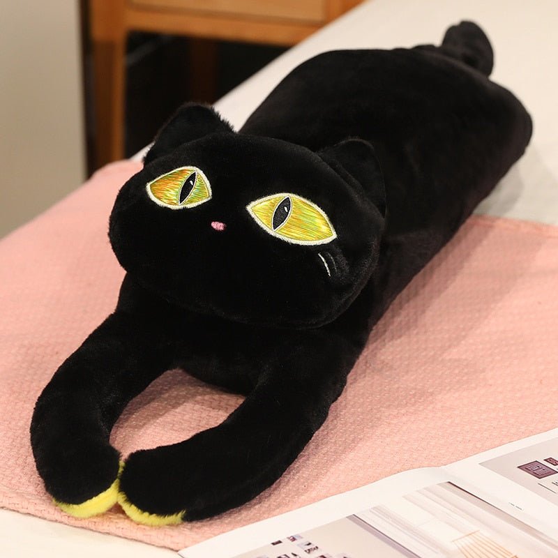 a black cat plushie with big yellow eyes