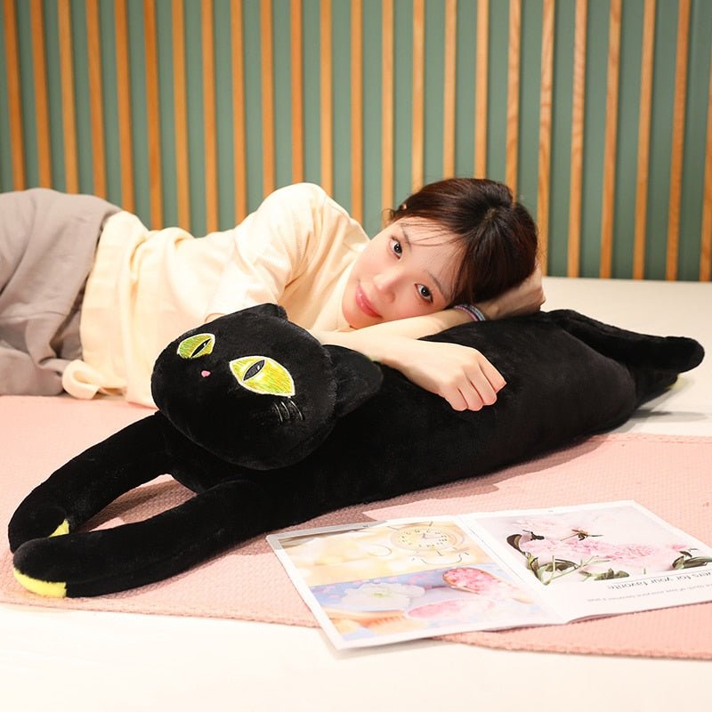 a woman holding a cat plushie of a black cat with big yellow eyes