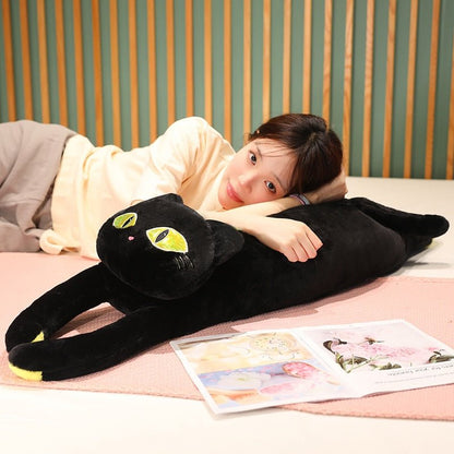 a woman holding a cat plushie of a black cat with big yellow eyes