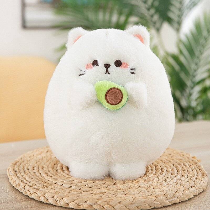 a stuffed white cat of a cat holding avocado