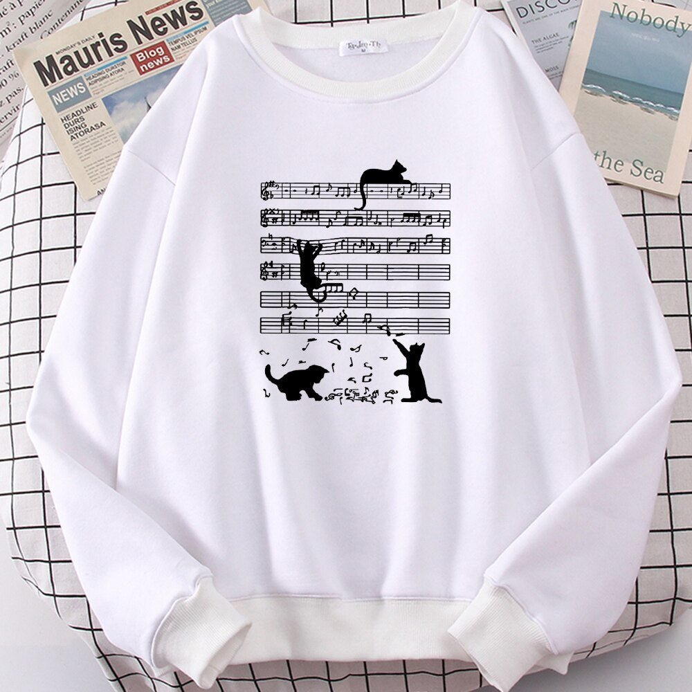 white cat sweatshirt with sheet music