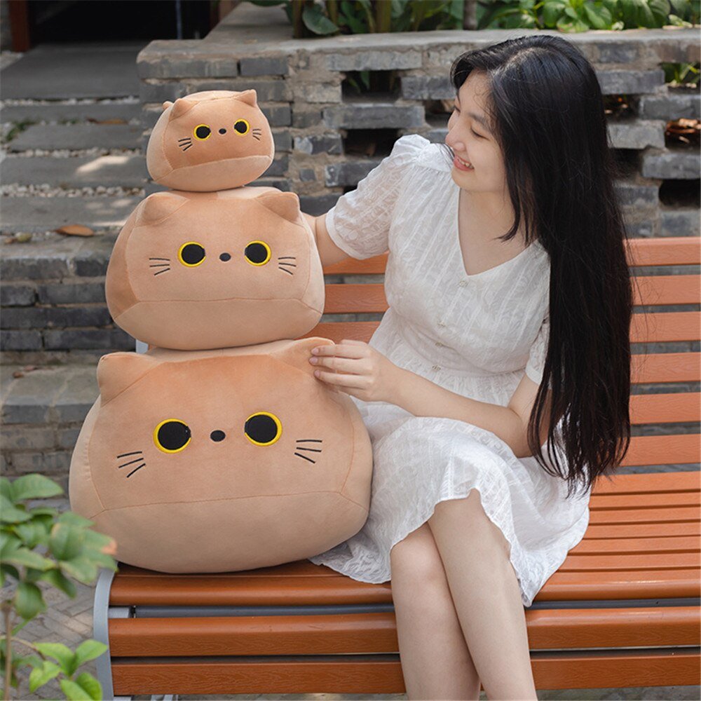 a woman with three different sizes of plushie cat
