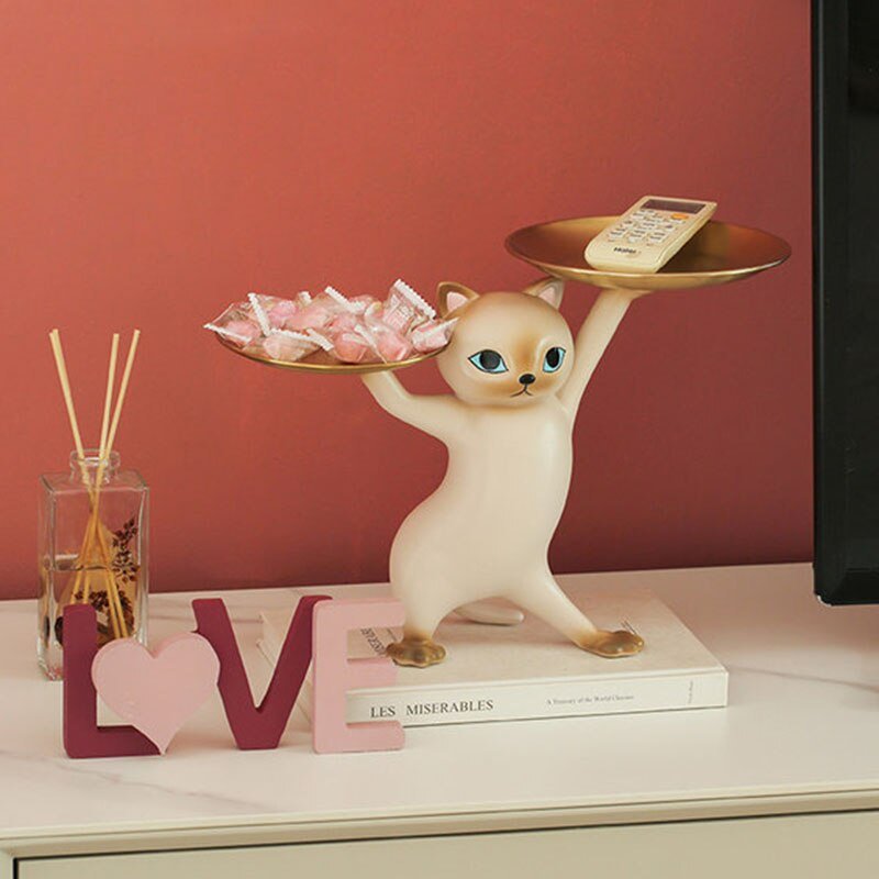 a white cat statue holding trays in a dancing pose