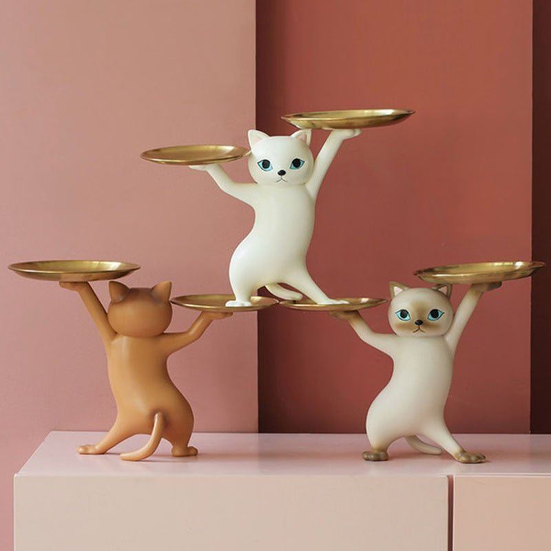 a group of cat sculptures in a dancing pose holding trays