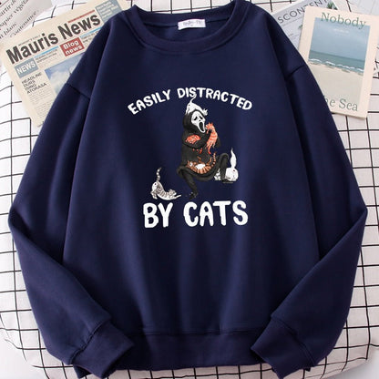 a navy blue cat print sweater with picture of ghost getting distracted by cats