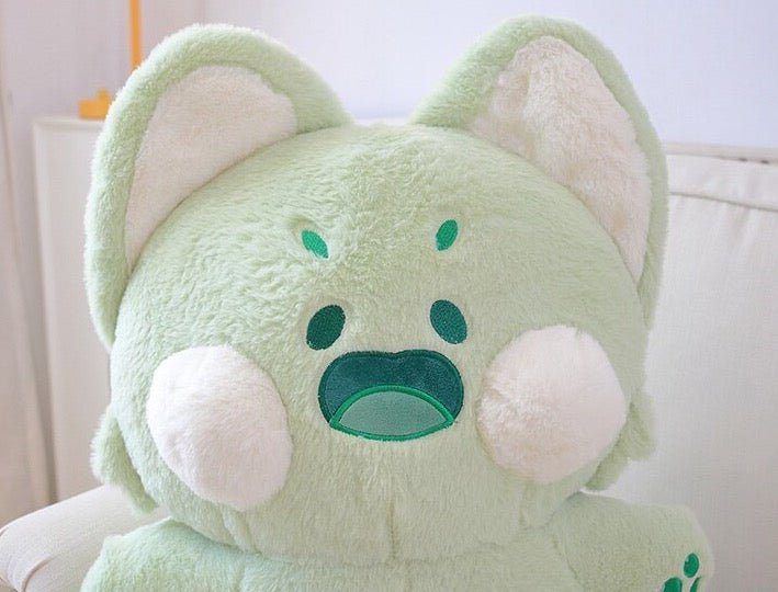 a close up of a cat plushie in green
