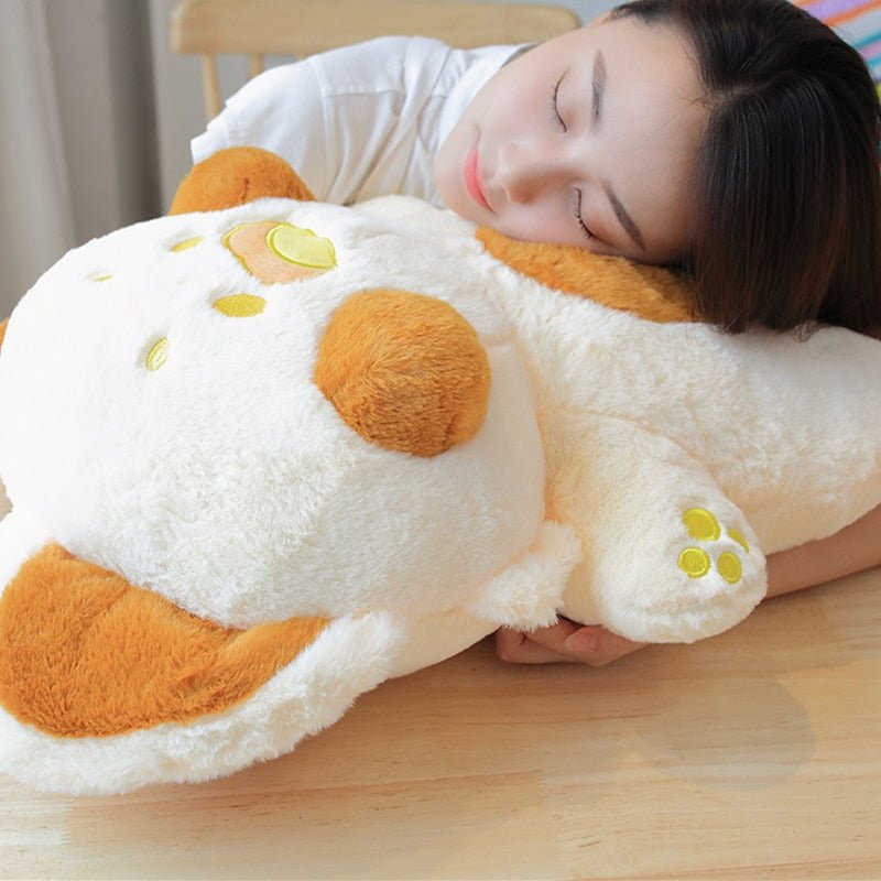 a lady sleeping on a pillow cat plush of a brown cat