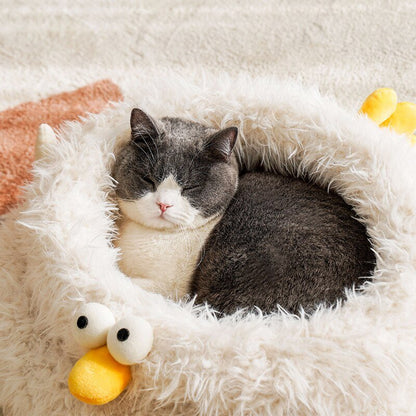 grey cat laying on a cute and comfy bed with chicken design