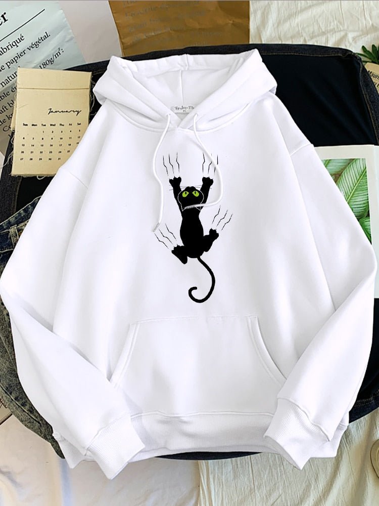 white color hoodie with a black cartoon cat climbing up the shirt which looks funny and hilarious