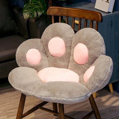 a fluffy gray and pink color cat paw chair cushion that is so comfy to put on a chair for cat lover