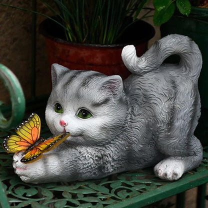 a cat garden sculpture holding a butterfly that is powered by solar for home decor