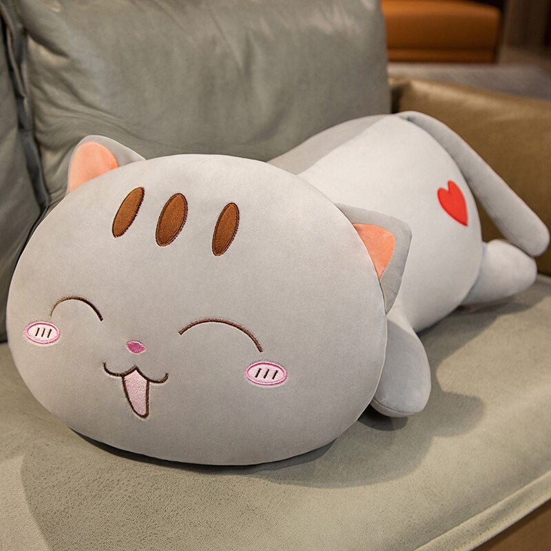 a plushie cat of a laying cat on a sofa