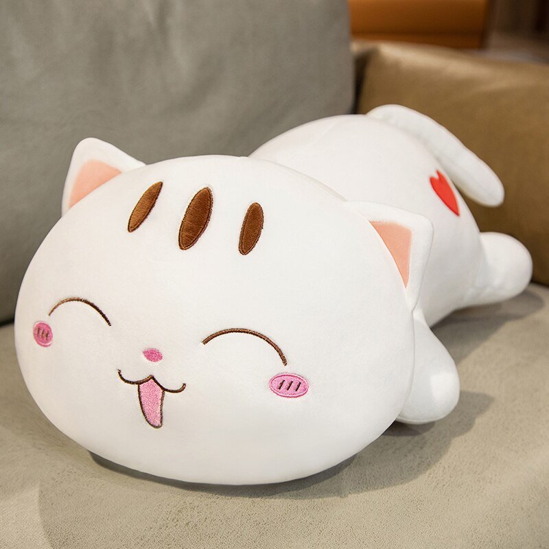 a white kawaii plush of a cat laying on a sofa