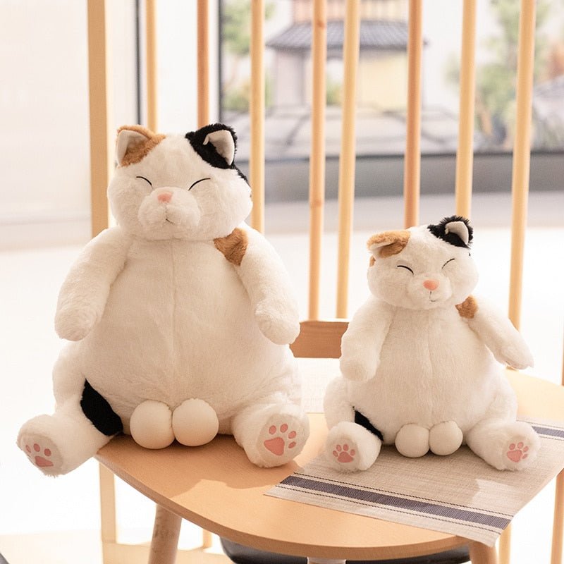 a japanese cat plush of calico cat on a table