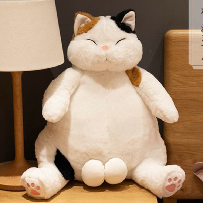 a big cat plush of calico cat on side table