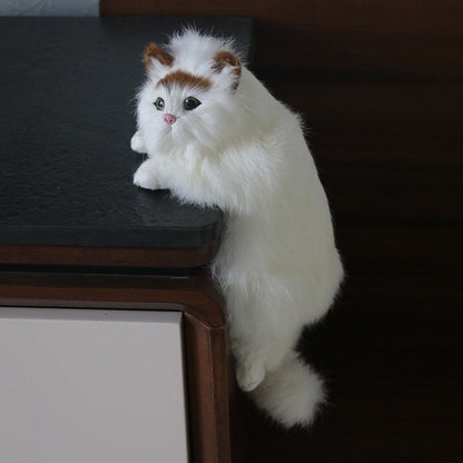 a white cat stuffed animal stuck on the table