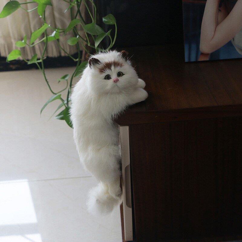 a kawaii cat plushie featuring a ragdoll cat stuck on a table