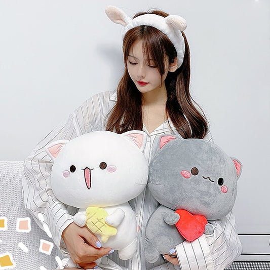 a lady hugging a white and grey cat plush
