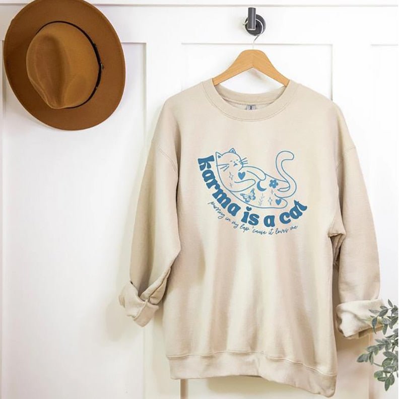 a beige color cat print sweatshirt with cute karma is a cat quote that looks cute