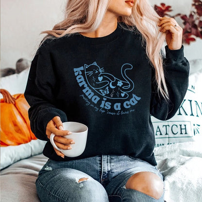 a woman wearing a black 'karma is a cat' sweatshirt that looks cute and vintage