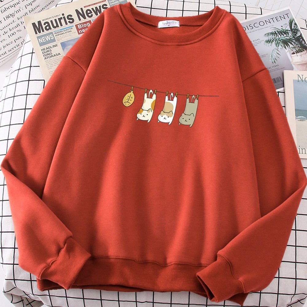 an orange colorcat lover sweatshirt with a picture of 3 cats getting laundry