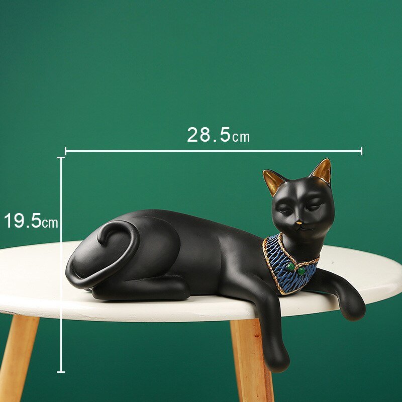a black cat sculpture of an egyptian cat with neck accessories in a laying pose